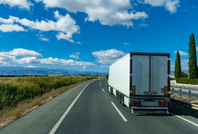 A refrigerated truck travelling on a clear, open highway, highlighting the importance of efficient route planning in cold chain logistics to maintain temperature control, ensure timely deliveries, and reduce operational costs. 